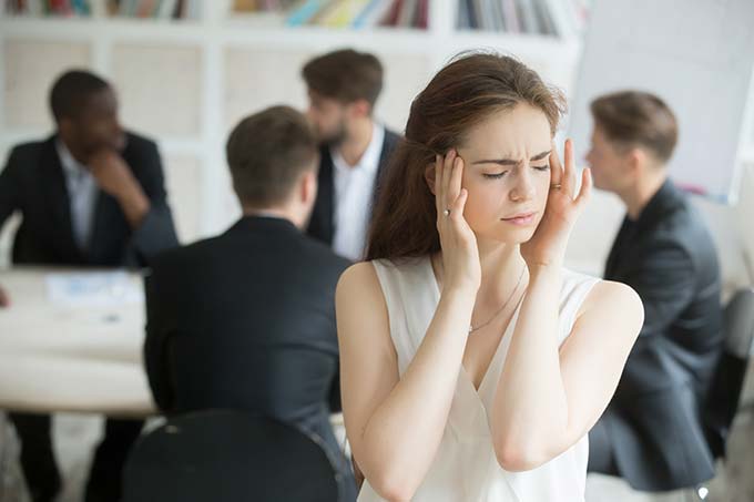 Frau hält sich die Ohren zu - Ursachen von Tinnitus